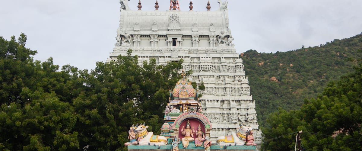 A temple with intricate carvings and a large statue on top.