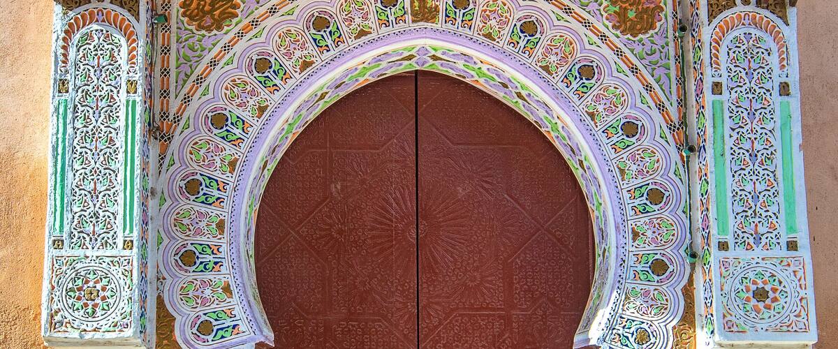 A wooden door with intricate carvings and a metal lock.
