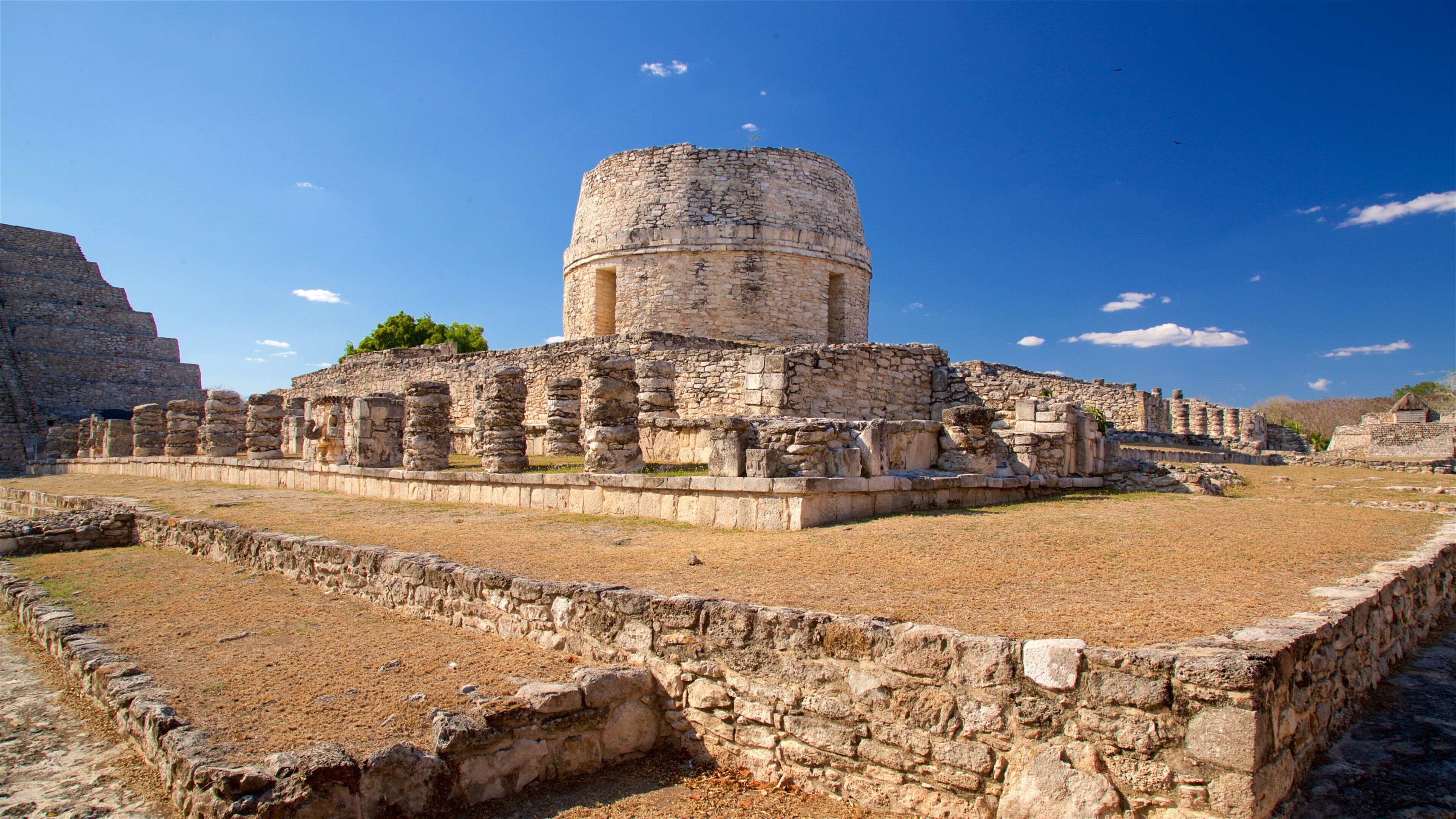 Ancient ruins with stone structures and a large central tower.