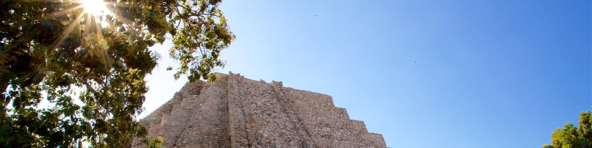 Mayapan Mayan Ruins showing a sunset and heritage architecture