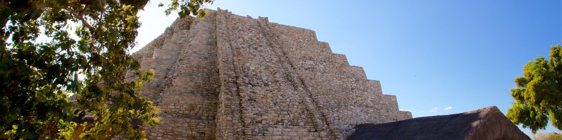Mayapan Mayan Ruins showing a sunset and heritage architecture
