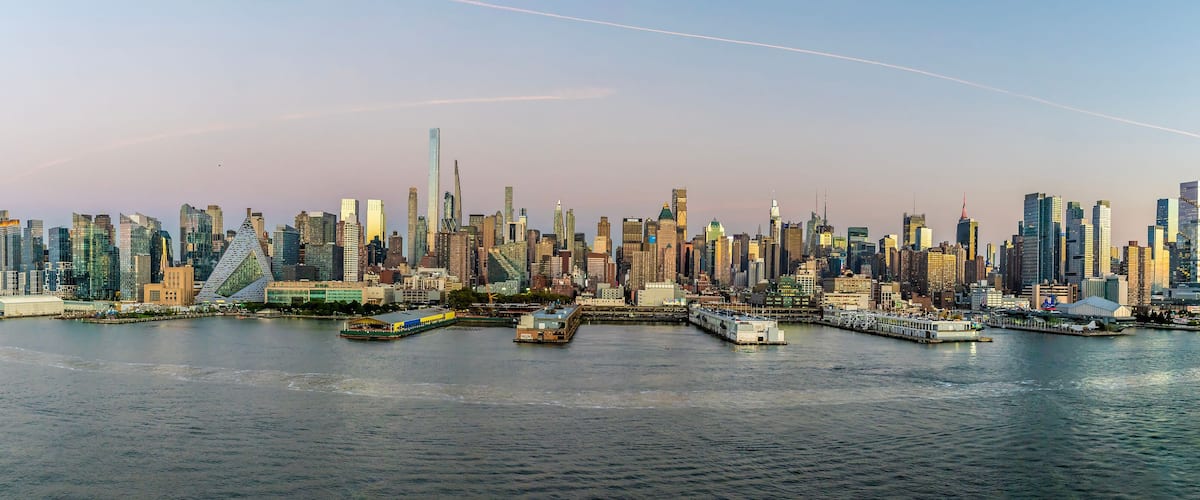 A panorama view approaching dusk from the Hudson River across the skyline of Manhattan, New York, in the fall