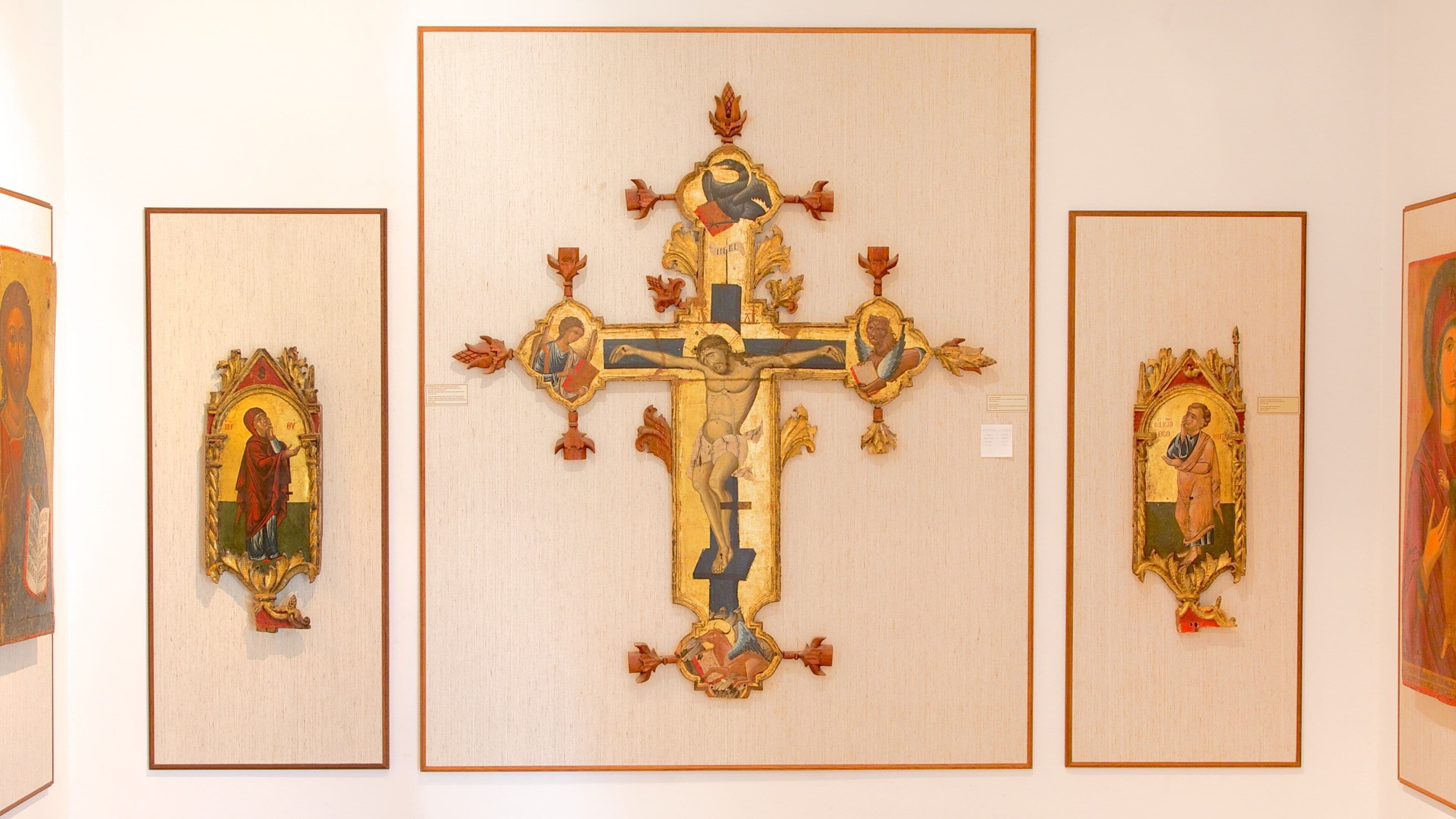 Eine religiöse Ausstellung mit einem zentralen Kruzifix, umgeben von aufwendigen Rahmen.