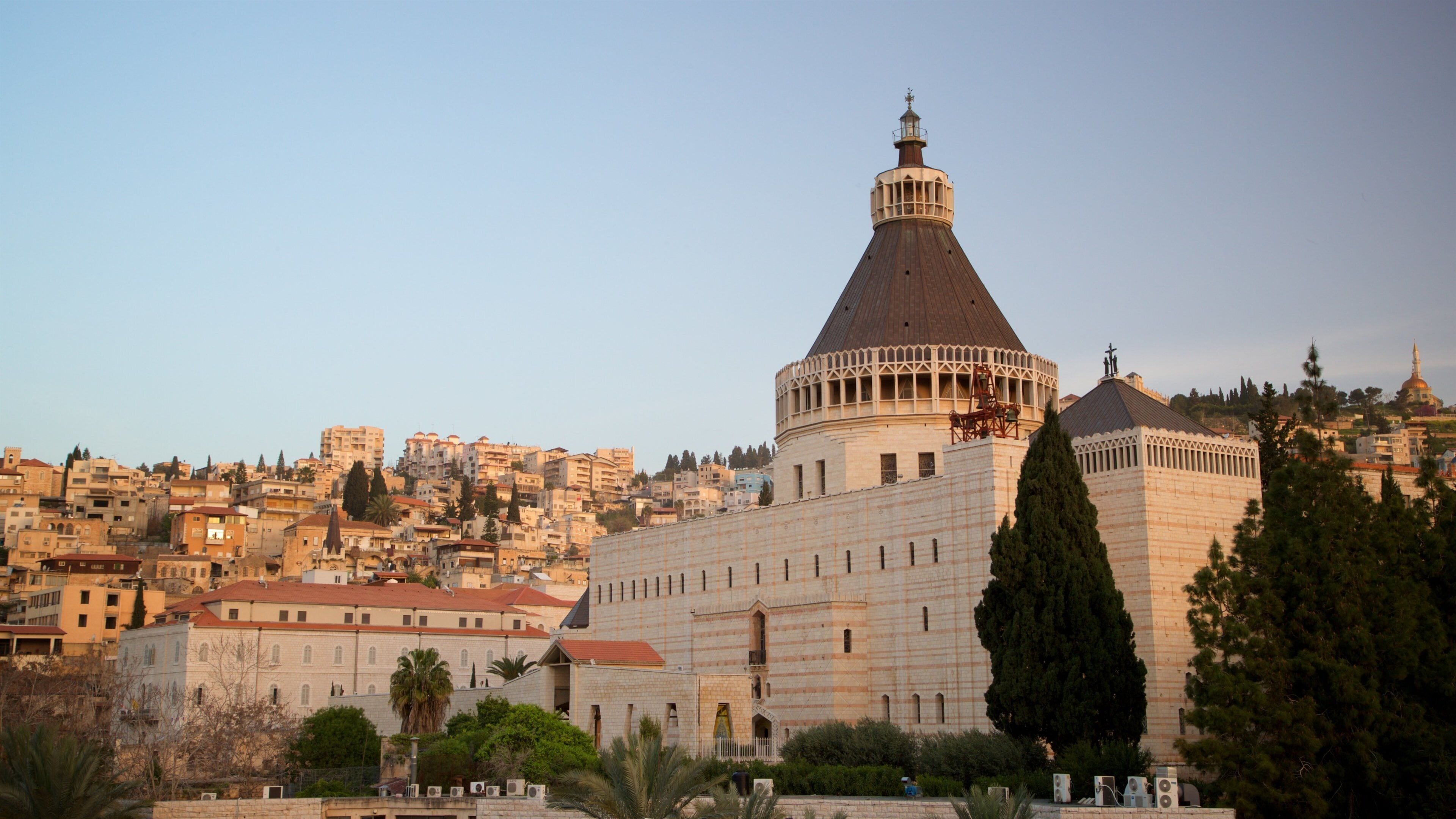 A historic building with a large dome and a smaller adjacent structure, surrounded by a cityscape with dense urban buildings.