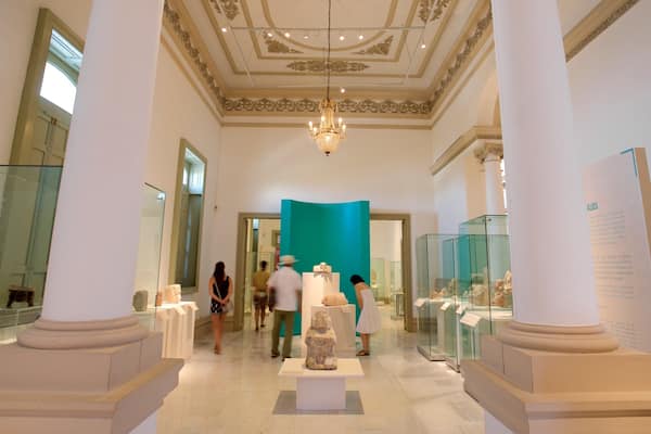 Museu em ambiente interno com arquitetura clássica, incluindo colunas e um lustre.