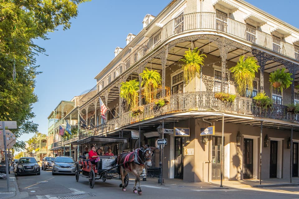 A historic building with ornate balconies and hanging plants.