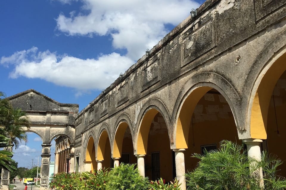A historic building with a series of arches and a cobblestone pathway.