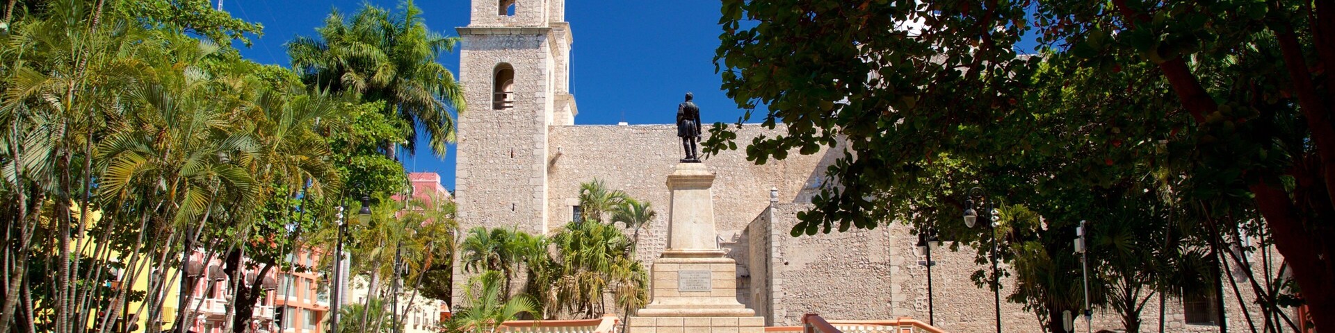 Una iglesia histórica con un campanario, una estatua y una escalera que la conduce.