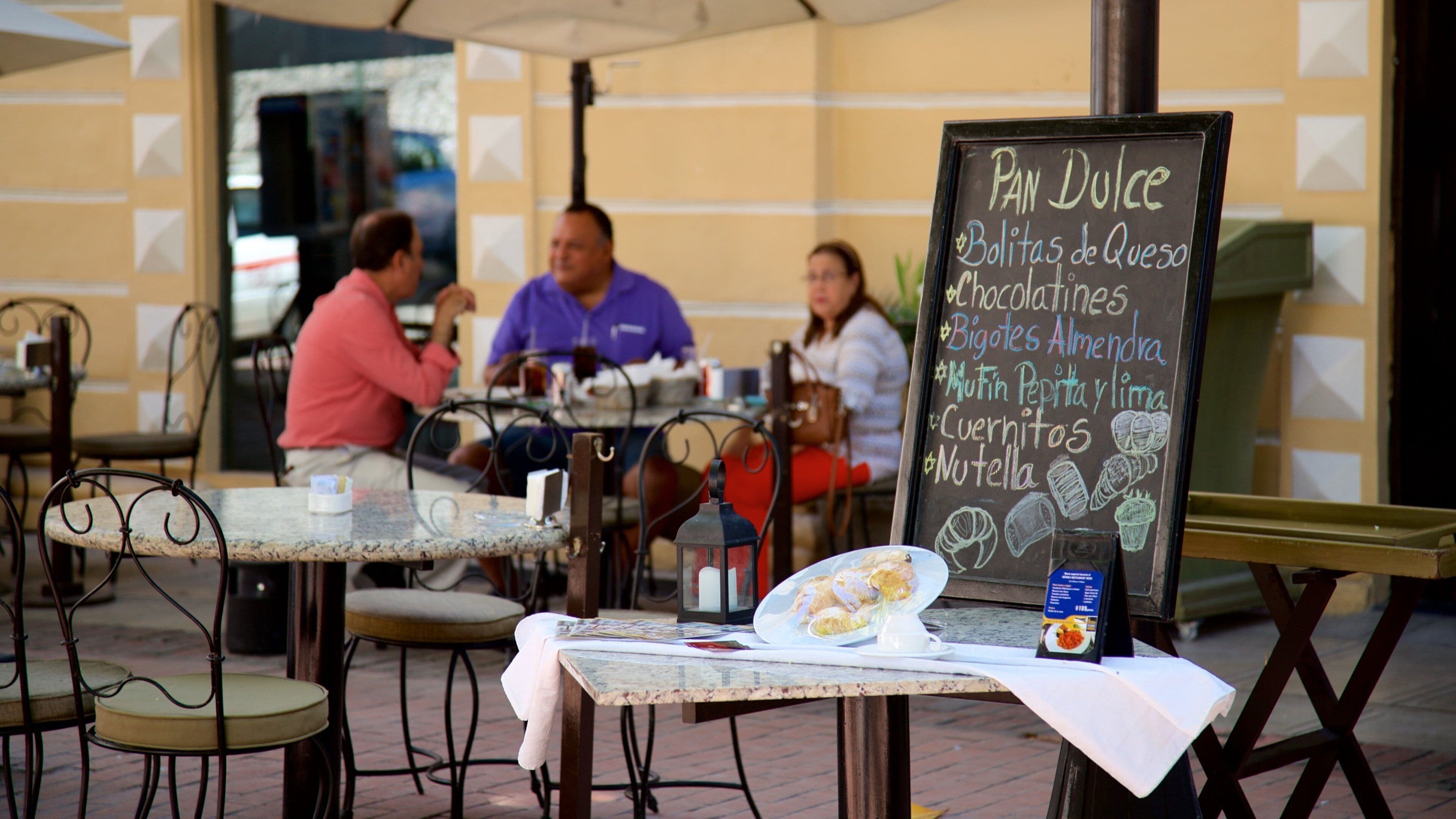 Hidalgo Park showing signage and outdoor eating as well as a small group of people