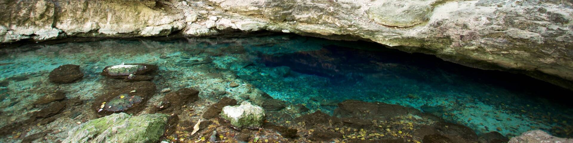 A cave with clear water and rocky formations.
