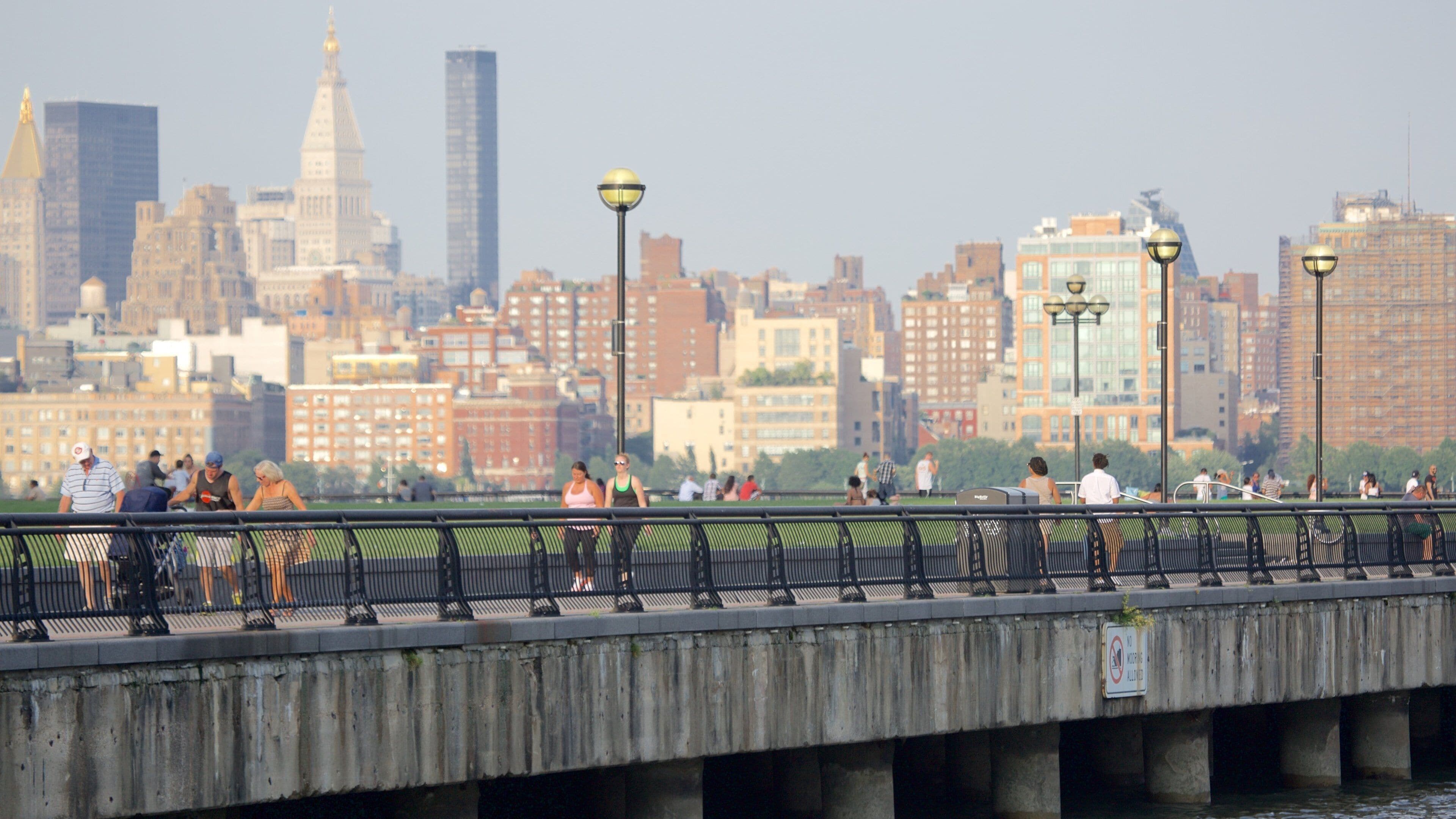 Muelles de Hoboken mostrando un puente y una ciudad y también un grupo grande de personas