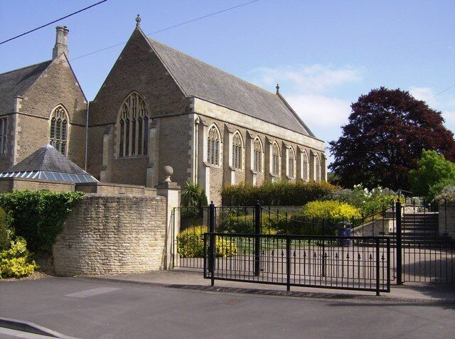 A stone church with a pointed roof and arched windows.
