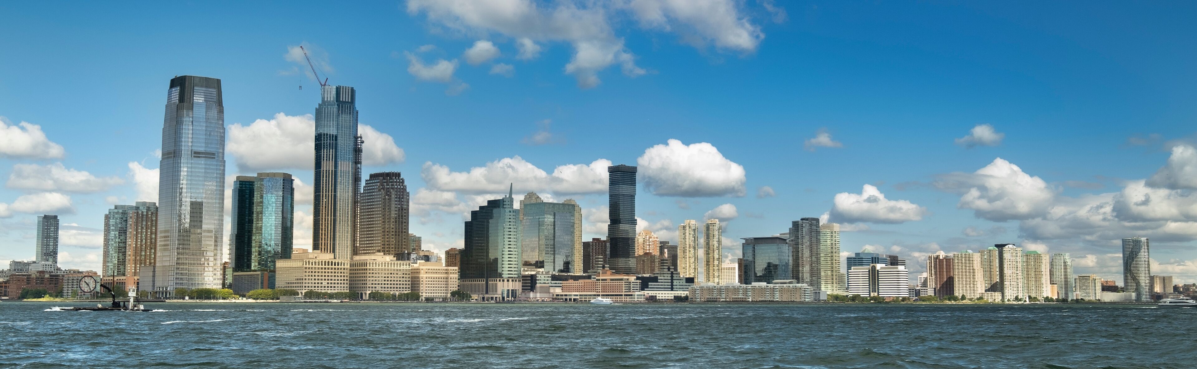 Skyline panoramic cityscape view from Battery Park of the office buildings and skyscrapers over the Hudson River waterfront of New Jersey USA