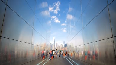 Un tunnel aux parois réfléchissantes, avec une vue sur les gratte-ciel d’une ville en arrière-plan.