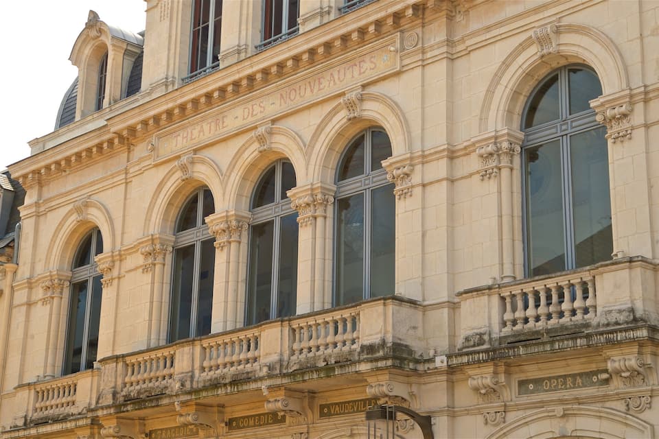 Um edifício histórico com detalhes arquitetônicos elaborados, incluindo janelas em arco e trabalhos em pedra decorativos.