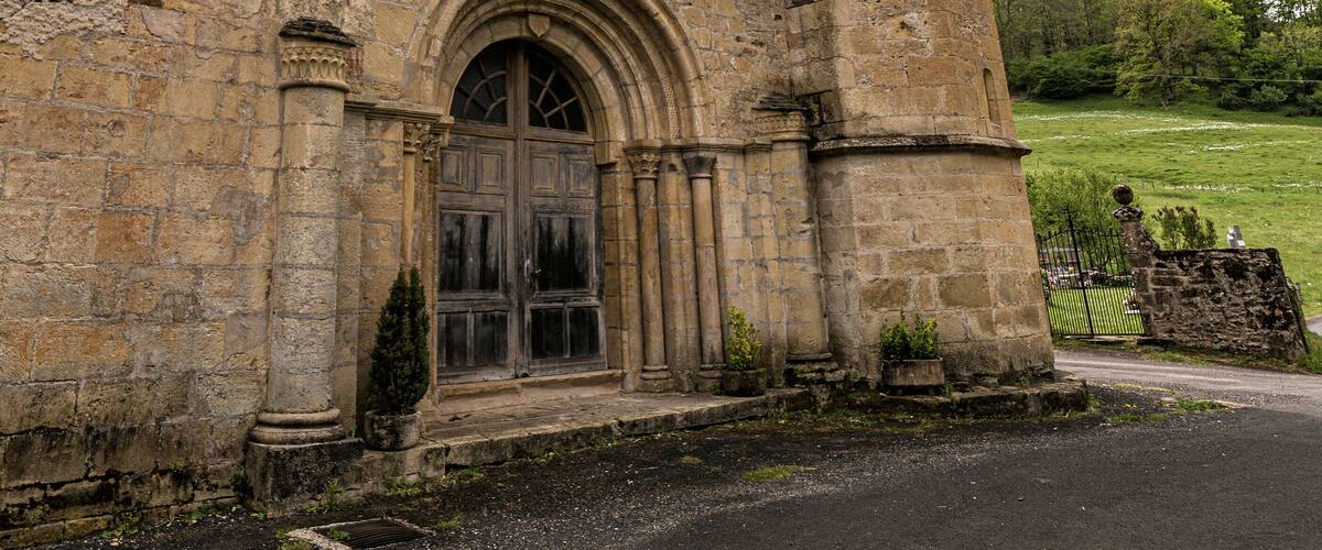 A historic stone building with a large arched entrance and a tower.