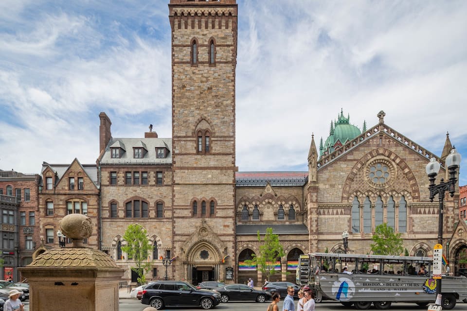 A historic building with a tall tower and a green dome.
