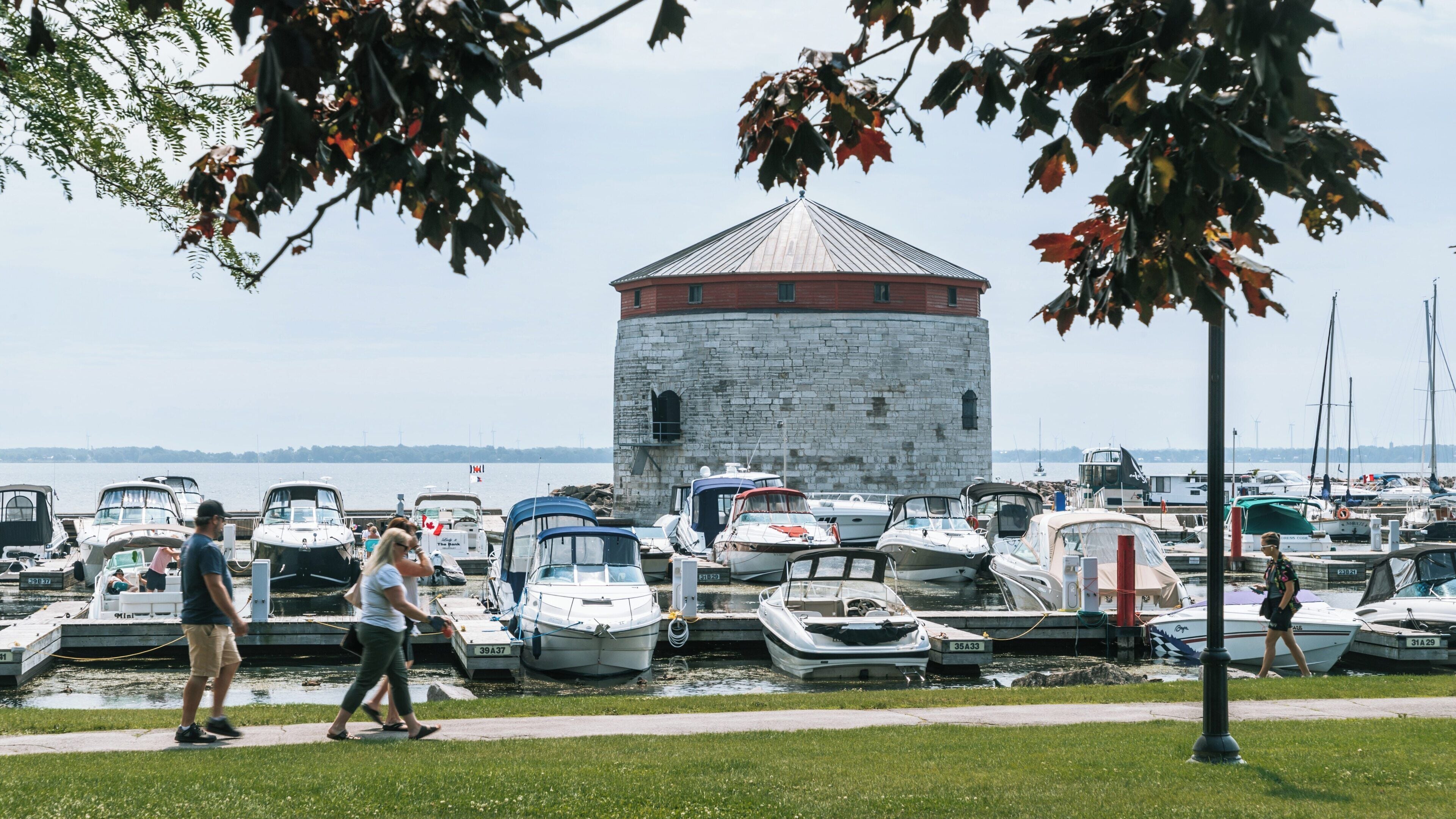 Exploring Kingston Waterfront featuring historic stone building and vibrant marina in Inner Harbour, Ontario during a sunny day
