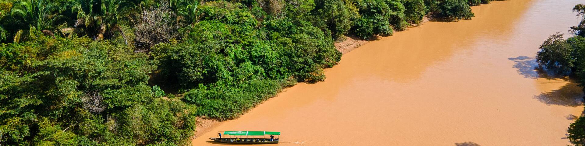 Muddy river with boat in Hato La Aurora, Colombia