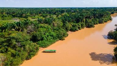 Muddy river with boat in Hato La Aurora, Colombia