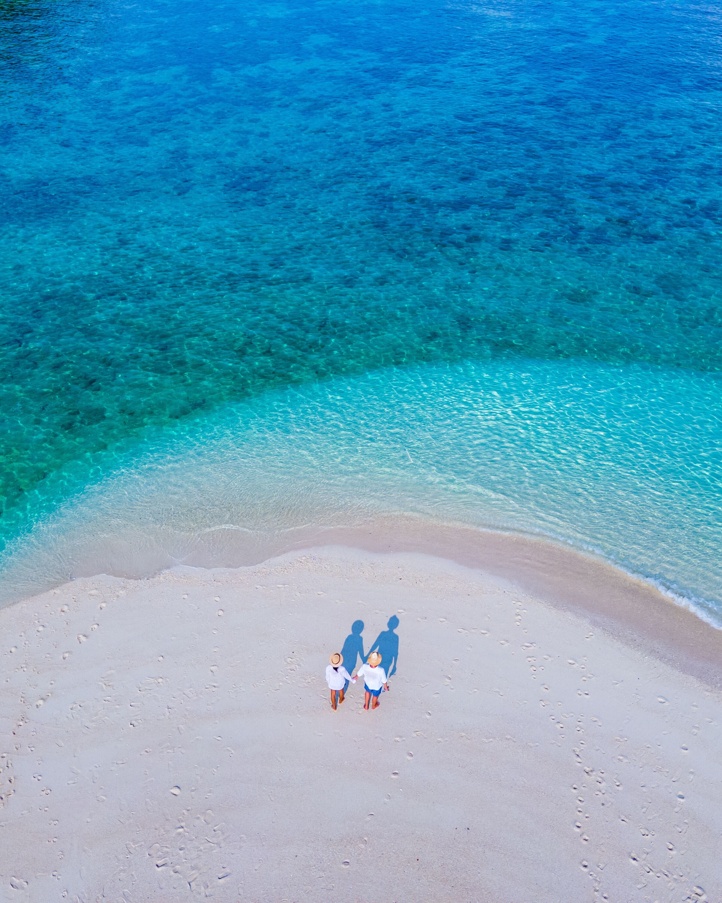 A beach with clear turquoise water and a sandy shore.