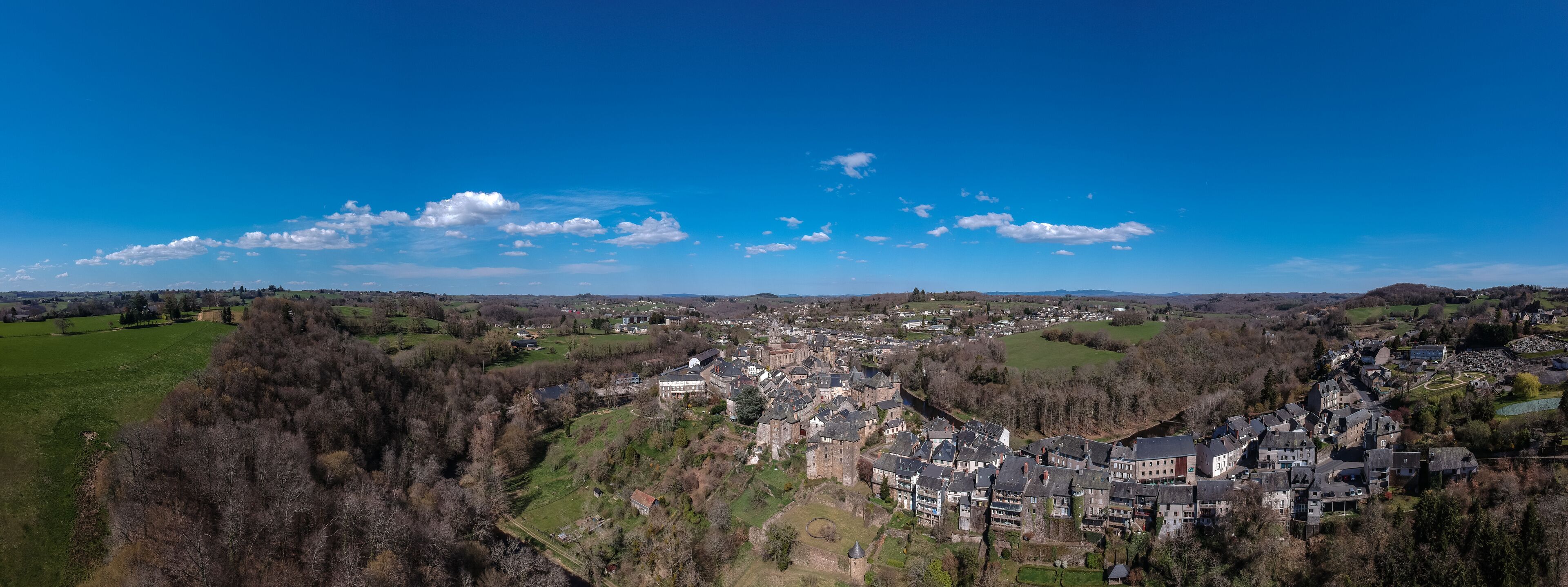 A town nestled in a valley with historic buildings and green fields.