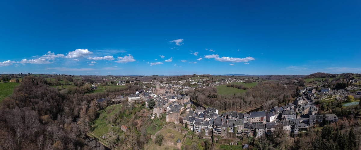 A town nestled in a valley with historic buildings and green fields.