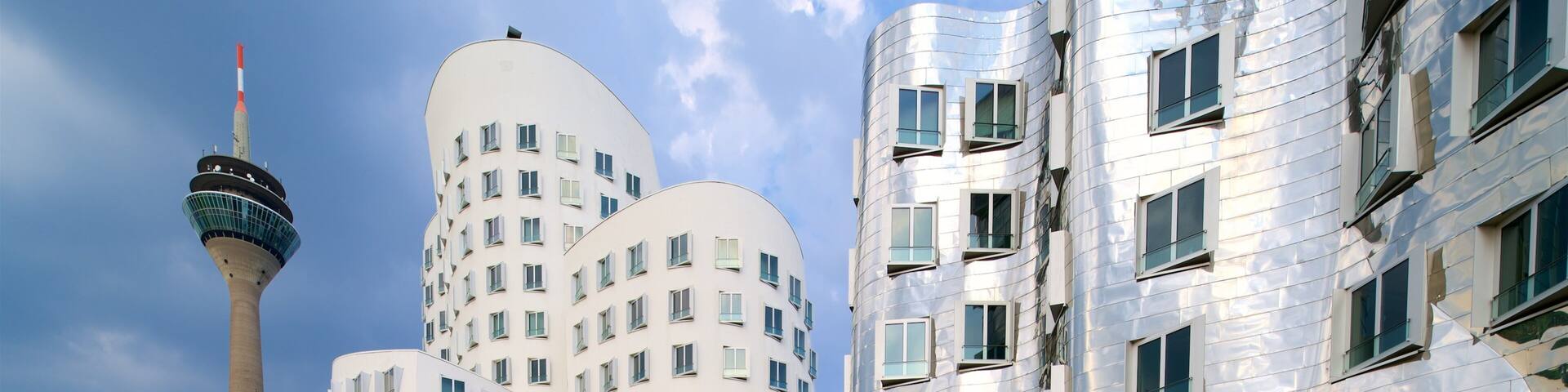 A modern urban area with distinctive architecture, including a tower and curved buildings.