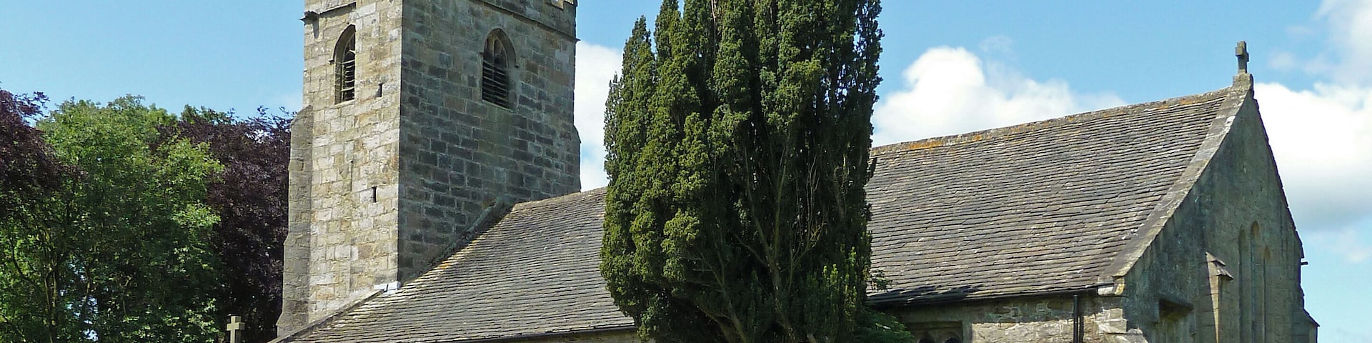 A grade I listed building. in open country east of the town, formerly in the West Riding of Yorkshire, now just on the Lancashire side of the border. The Pendle Way passes through the churchyard. English Heritage says of it: probably C15 and early C16 (tower said to be dated 1524), with C13 remains. Random rubble except tower of dressed stone, stone slate roof. Continuous nave and chancel, south aisle and porch, and west tower. Tower is rectangular and simply treated with gargoyle string course and embattled parapet. Diagonal buttresses and square stair turret at south east corner. West window with arched head of 3-lights, and belfry openings of 2-lights with louvres, also arched, all with hood-moulds. South aisle has simple gabled porch with cambered head to entrance in first bay, then three double chamfered windows with flat heads and round arched lights. Squat offset buttresses, and a nearly central priest's door, flat headed with single chamfer. The west window of this aisle is of 3 cusped lights. Three windows of the more usual type in the north wall. At the eastern end of this wall is a lancet of C13 type, and the east window has a stepped arrangement of 3 similar, above a short pilaster buttress.