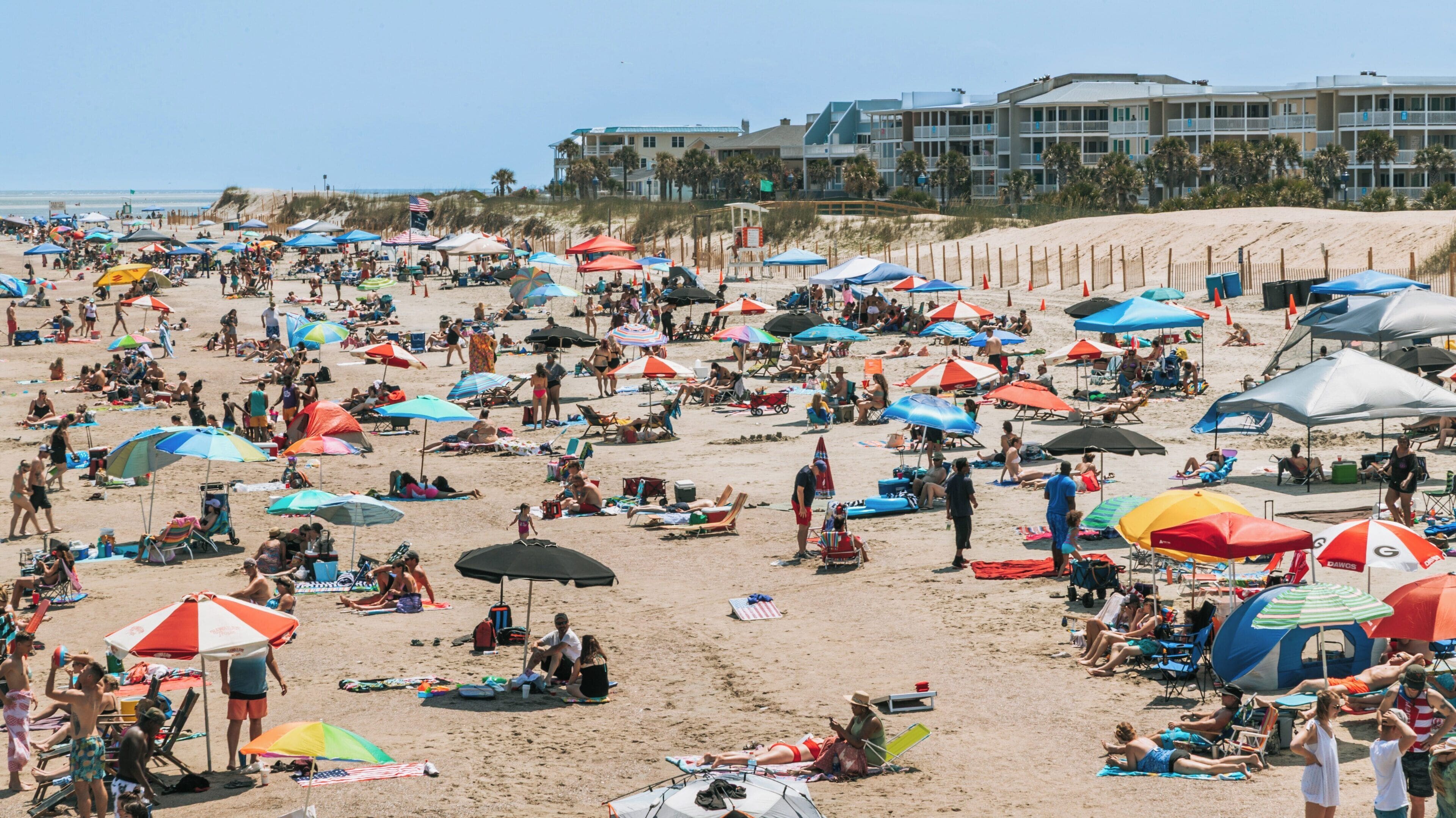 Crowded Tybee Island Beach in Georgia filled with umbrellas and sunbathers enjoying a sunny day