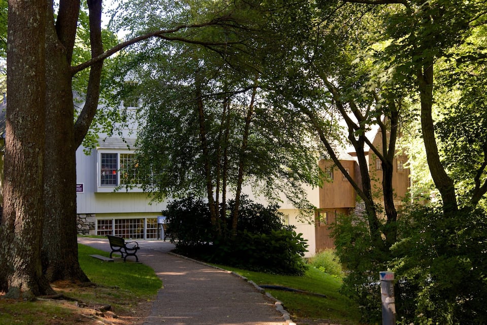 A pathway leading to a building surrounded by trees.