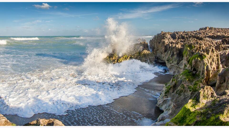 A rocky coastline with waves crashing against the shore.
