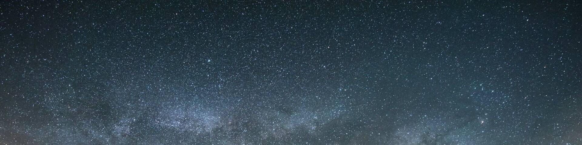 A panorama of Milky Way over the lake and reflections of the stars. A beautiful spot for camping and gazing at stars on a dark night. Near San Diego, California