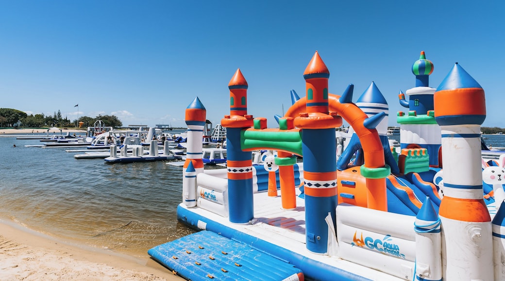 A colorful inflatable play structure by the water.