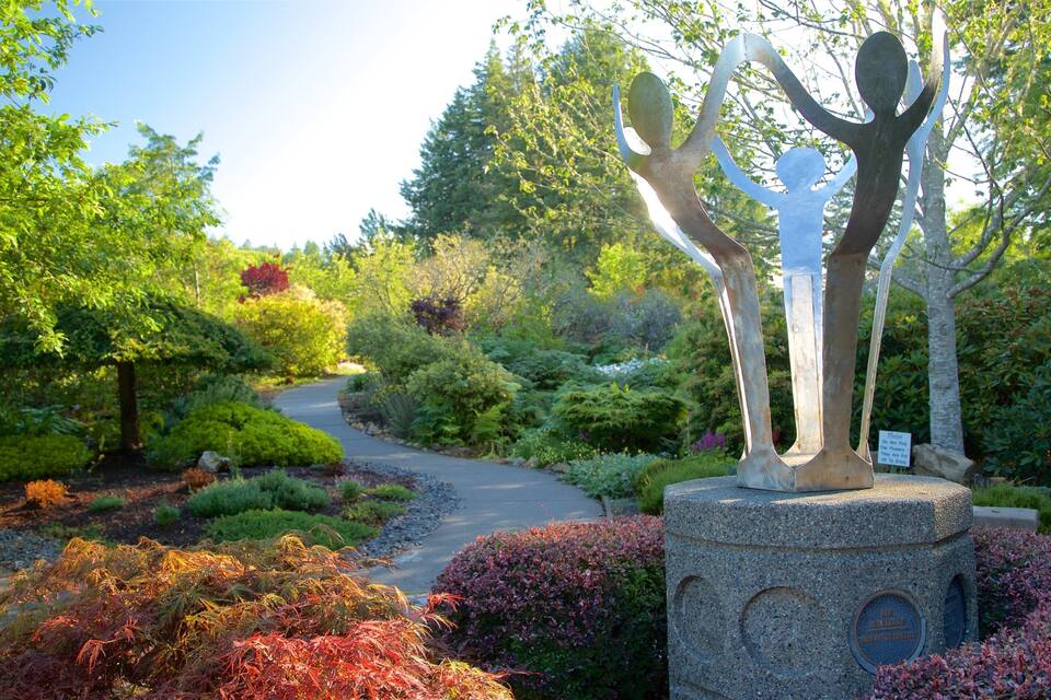 A garden with a sculpture of a tree, a winding path, and various shrubs.