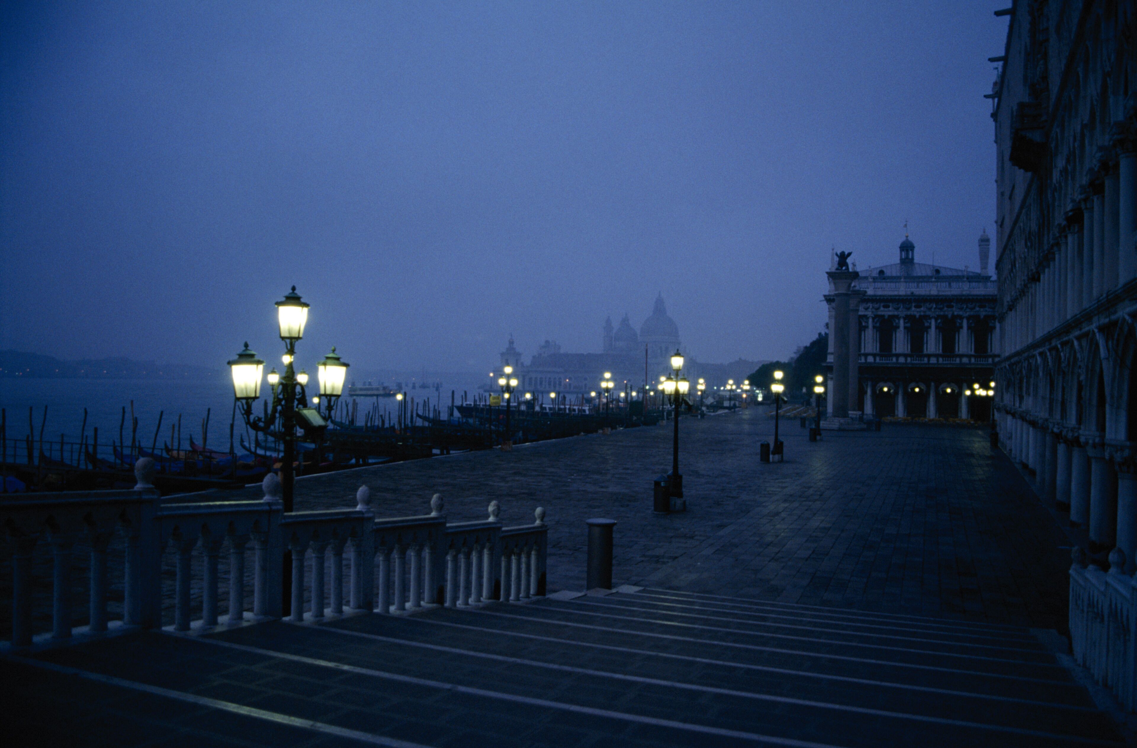 A nighttime view of a grand staircase leading up to a historic building with classical architecture.