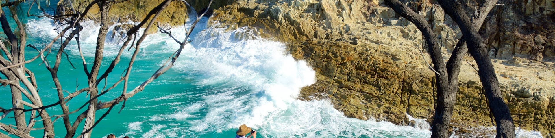 North Stradbroke Island showing surf and rugged coastline as well as a small group of people