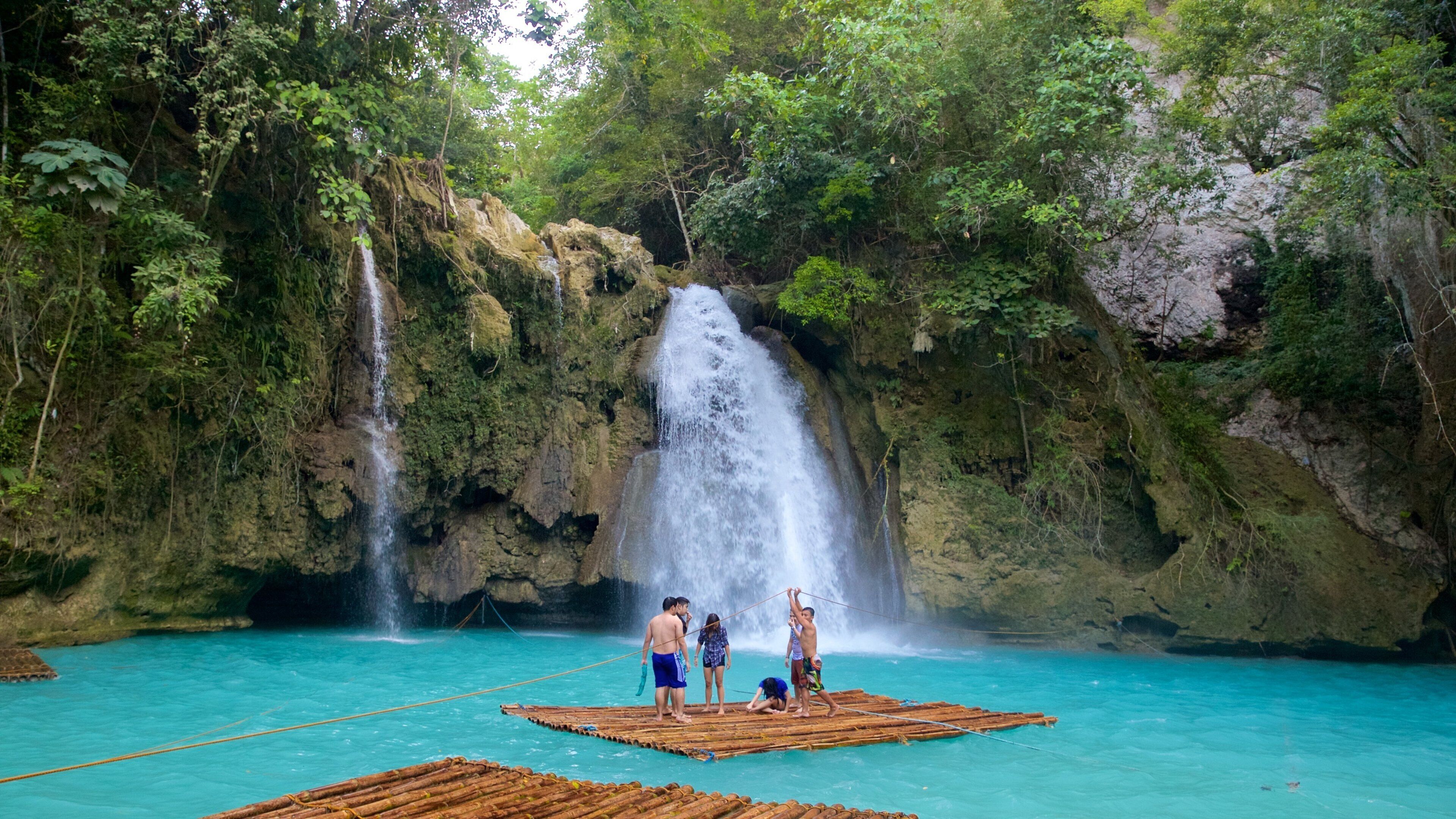 Cataratas de Kawasan mostrando una catarata y también un pequeño grupo de personas