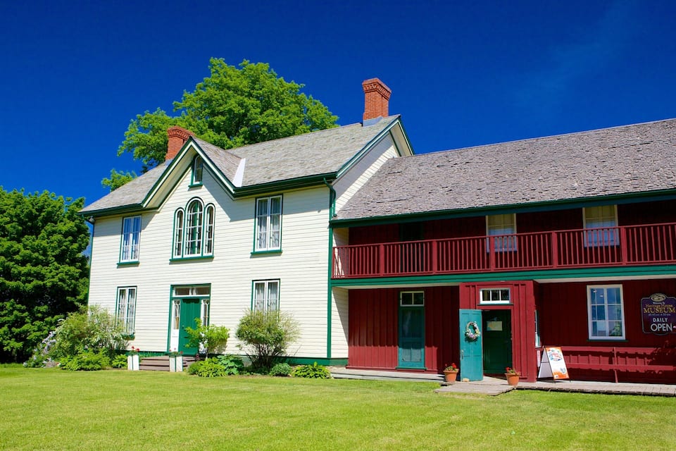 A historic house with green trim and a red front porch.