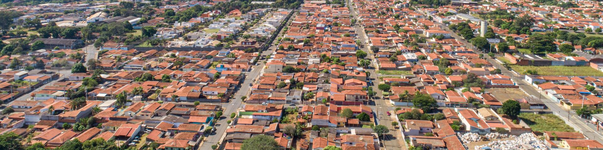 A densely populated urban area with red-roofed residential buildings and scattered greenery.