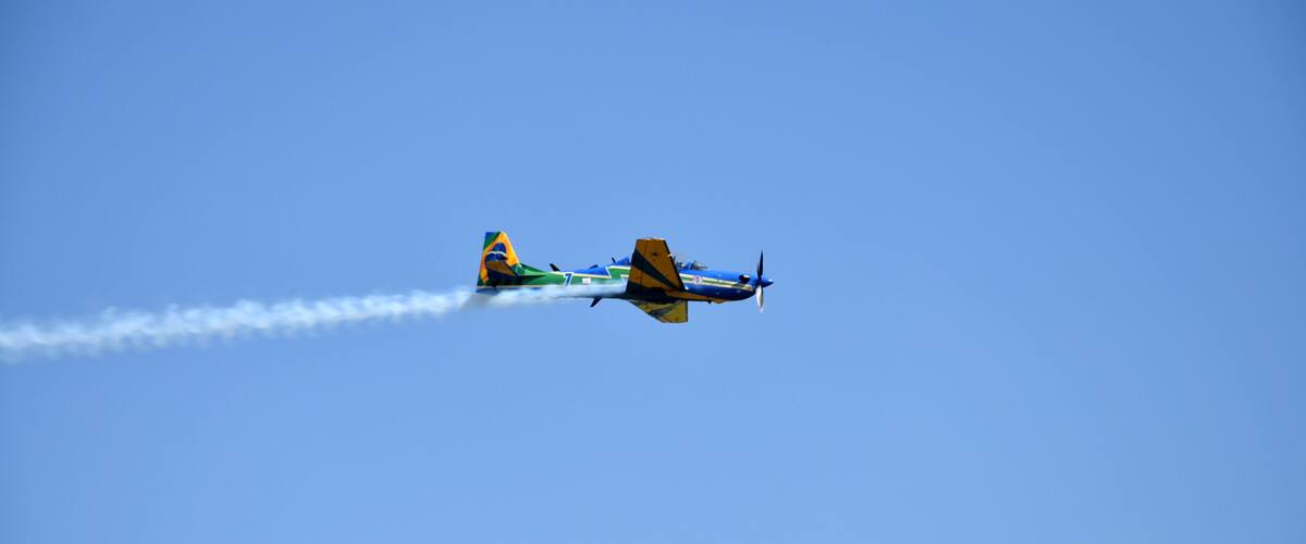 Two airplanes flying in formation with smoke trails.