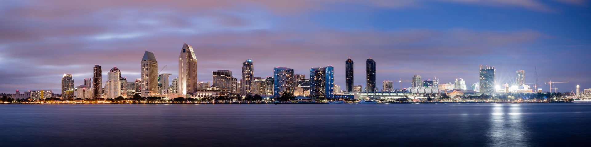 Horizonte urbano com arranha-céus e uma ponte sobre a água.