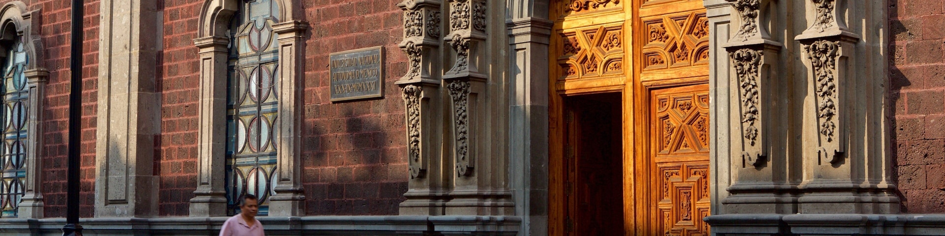 Um edifício histórico com portas de madeira ornamentadas e detalhadas esculturas em pedra.
