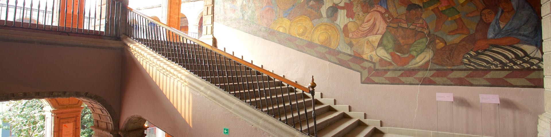A grand staircase with a mural on the wall.
