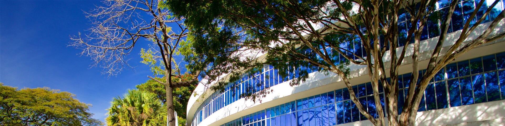 A modern building with a glass facade and a sign reading "Biblioteca Pública Estadual Luiz de Bessa".