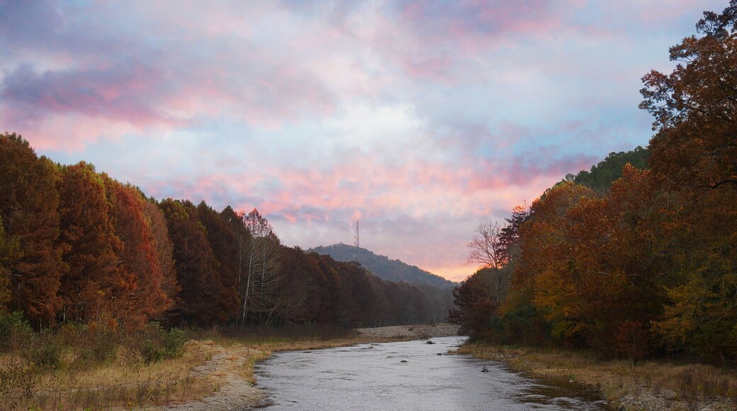 The tranquil Mountain Fork River flowing at the Beavers Bend State Park in Broken Bow, Oklahoma with colorful leaves on the trees on a beautiful autumn day.
