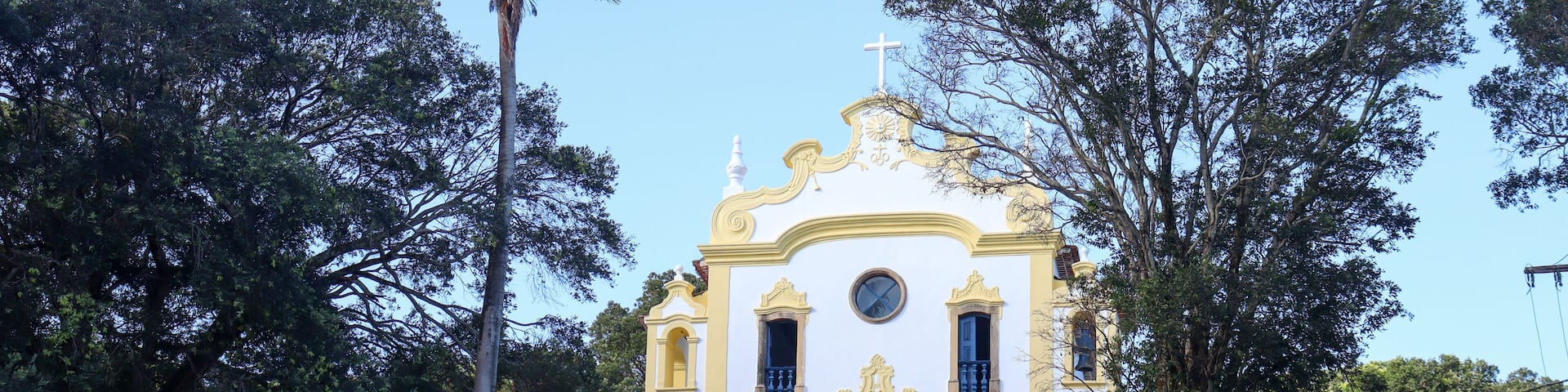 Histórica Igreja Nossa Senhora dos Remédios em Noronha, cenário da vila, turistas explorando a cultura local, arquitetura colonial preservada, experiência única na ilha