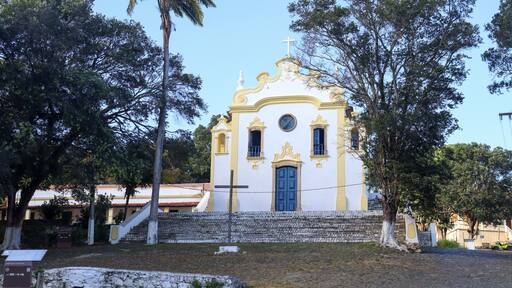 Histórica Igreja Nossa Senhora dos Remédios em Noronha, cenário da vila, turistas explorando a cultura local, arquitetura colonial preservada, experiência única na ilha