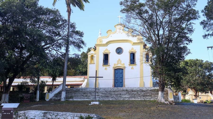 Histórica Igreja Nossa Senhora dos Remédios em Noronha, cenário da vila, turistas explorando a cultura local, arquitetura colonial preservada, experiência única na ilha