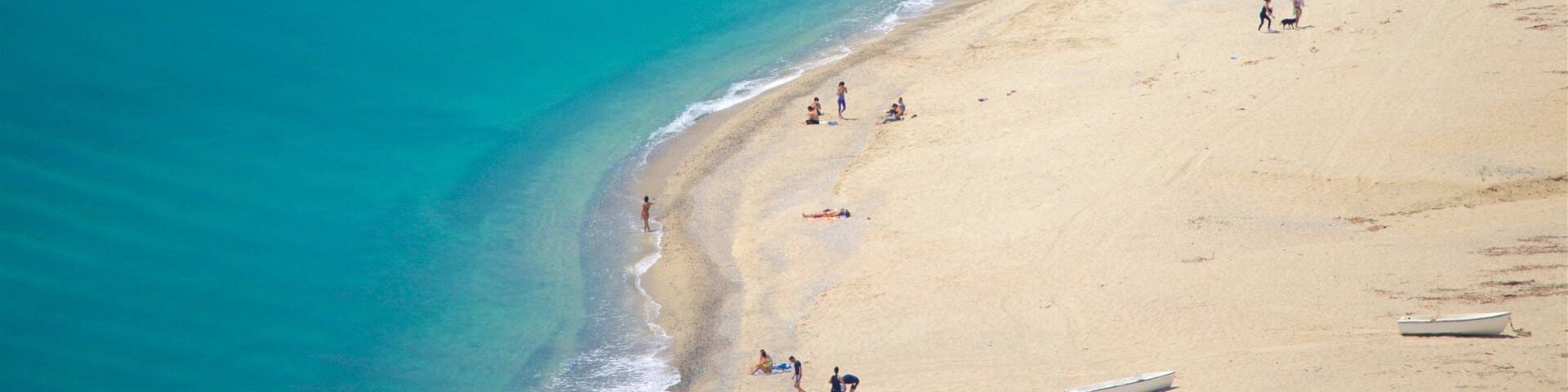 Caminia Beach which includes general coastal views and a sandy beach as well as a small group of people